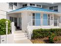 Charming condo exterior featuring a blue roof, white siding, and a welcoming front entrance with blue doors at 866 Audubon Dr, Bradenton, FL 34209