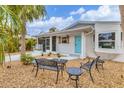 Well-kept home exterior featuring a quaint seating area and a bright blue front door at 310 Magnolia Ave, Anna Maria, FL 34216