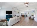 Spacious living room featuring wood look floors, ceiling fans, and lots of natural light at 400 Dona Dr, Nokomis, FL 34275