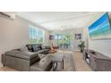 Bright living room with a modern leather sofa, stylish decor and balcony access at 4207 Marina View Way, Cortez, FL 34215