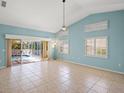 Open-concept living area with vaulted ceilings, tile floors, natural light, and access to the screened pool area at 4410 Murfield E Dr, Bradenton, FL 34203
