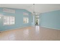 Light-filled living room with tile floors, vaulted ceiling, modern light fixture, and an inviting atmosphere at 4410 Murfield E Dr, Bradenton, FL 34203