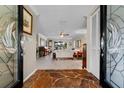 Inviting foyer with stone floors and decorative glass doors, leading into a bright and airy living space at 5036 Willow Leaf Way, Sarasota, FL 34241