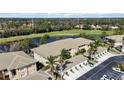 Scenic aerial view of condo with lush landscaping, a community pond, and a golf course in the background at 6326 Grand Oak Cir # 101, Bradenton, FL 34203