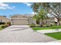 Well-maintained single-story home featuring a two-car garage, landscaped front yard, and brick driveway at 7731 Camden Harbour Dr, Bradenton, FL 34212