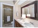 Updated bathroom featuring double sinks, a large mirror, and a tiled glass shower at 805 Spring Lakes Blvd # 805, Bradenton, FL 34210