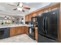 Bright kitchen with oak cabinets, black appliances, and a view into the living area at 805 Spring Lakes Blvd # 805, Bradenton, FL 34210