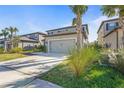 Stylish two-story home with a two-car garage, driveway, and lush tropical foliage at 8609 Evening Dr, Sarasota, FL 34241