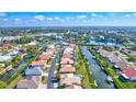 An aerial view shows a home on a canal with access to a bay, surrounded by mature trees and other homes at 104 Inlets Blvd # 104, Nokomis, FL 34275