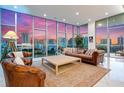 Elegant living room with floor-to-ceiling windows offers panoramic city views and stylish leather furniture at 1335 2Nd St # 402, Sarasota, FL 34236