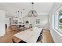 Open-concept dining room with wood floors, a large light fixture, and easy access to the kitchen at 2202 Waldemere St, Sarasota, FL 34239