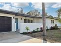 Inviting home exterior with a blue front door, manicured landscaping, and a convenient two-car garage at 2746 Tangelo Dr, Sarasota, FL 34239