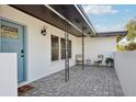 Covered front porch with tiled flooring, stylish seating, and a welcoming entrance to the home at 2746 Tangelo Dr, Sarasota, FL 34239