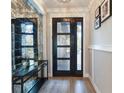 Inviting entryway featuring wood flooring, a modern front door, and a stylish mirrored wall at 2823 Marshall Dr, Sarasota, FL 34239