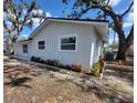 Side view of a one-story home featuring fresh landscaping, newly painted exterior and white trim at 3325 Woodmont Dr, Sarasota, FL 34232