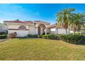 Attractive single-story home boasts a red tile roof, beautiful landscaping, and a manicured lawn at 5080 Kilty E Ct, Bradenton, FL 34203