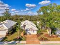 Aerial view of home showcasing the roof, garage, driveway and surrounding yard with mature trees at 538 Fallbrook Dr, Venice, FL 34292