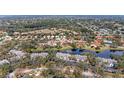 Serene aerial view of community with lush greenery, pond, and beautiful single-Gathering homes at 5513 83Rd E Ter, Sarasota, FL 34243