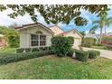 Inviting one-story home featuring a red tile roof, large windows, and beautifully landscaped front yard at 5513 83Rd E Ter, Sarasota, FL 34243