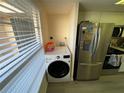 Convenient laundry area featuring a modern washing machine adjacent to the stainless steel refrigerator at 6330 7Th W Ave, Bradenton, FL 34209