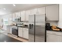 Modern kitchen with stainless steel appliances, granite countertops, and sleek gray cabinets at 6708 162Nd E Pl, Parrish, FL 34219