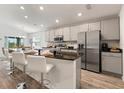 Stylish kitchen island with stainless steel appliances, granite countertops, and modern white barstools at 6708 162Nd E Pl, Parrish, FL 34219