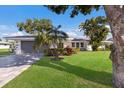 Charming single-story home boasts a well-manicured lawn, lush landscaping, and a paved driveway leading to a gray two-car garage at 7204 18Th W Ave, Bradenton, FL 34209