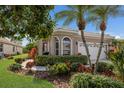 Charming home exterior with lush, colorful landscaping and a well-manicured lawn at 7608 Teal Trce, Bradenton, FL 34203