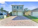 Inviting two-story home featuring a brick-paved driveway and a single-car garage at 1122 42Nd E Ter, Bradenton, FL 34208