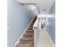 Carpeted staircase leading to the upper level, adjacent to a hallway with tile flooring at 1122 42Nd E Ter, Bradenton, FL 34208