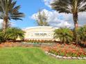 Inviting entrance sign to The Isles on Palmer Ranch with colorful flowers and lush landscaping at 11629 Garessio Ln, Sarasota, FL 34238