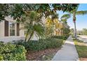 Street view of attractive townhomes boasting well-maintained landscaping and charming architectural details at 1555 Napoli W Dr, Sarasota, FL 34232