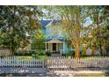 Charming two-story home with lush landscaping and a welcoming white picket fence at 1609 1St W Ave, Bradenton, FL 34205