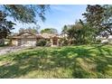 Inviting front yard with mature trees shading a classic home with brick and wood accents at 1612 Pine Harrier Cir, Sarasota, FL 34231