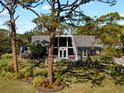 Unique home with A-frame window, inviting porch, and a beautifully landscaped yard at 1627 Bayshore Dr, Englewood, FL 34223