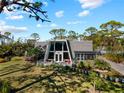 Distinctive home with an A-frame window design, a lovely porch, and a well-manicured lawn at 1627 Bayshore Dr, Englewood, FL 34223