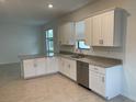 Bright kitchen featuring white cabinets, stainless steel appliances, granite countertops, and a view from the window at 19715 Tortuga Cay Dr, Venice, FL 34293