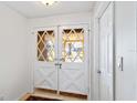 Bright foyer showcasing elegant double front doors with decorative glass and adjacent coat closet at 2118 Wells Av, Sarasota, FL 34232