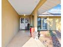 Inviting covered front porch with double doors, tile flooring, plants, and accentuating architectural details at 2118 Wells Av, Sarasota, FL 34232