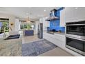 Contemporary kitchen with a stainless steel hood, white cabinets, a patterned rug, and a view to the outside at 3301 River Woods Dr, Parrish, FL 34219