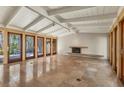 Open living room features exposed beams, a minimalist fireplace, and travertine flooring at 344 Monroe Dr, Sarasota, FL 34236