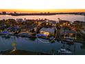 Sunset aerial view of waterfront estate home with pool and boat dock in a tropical setting at 355 W Royal Flamingo Dr, Sarasota, FL 34236