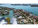 Gorgeous aerial view of waterfront home featuring a private dock, pool, and lush landscaping at 355 W Royal Flamingo Dr, Sarasota, FL 34236