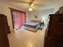 Bedroom features tile floors, a ceiling fan, and access to the lanai via sliding doors at 4197 66Th Street W Cir, Bradenton, FL 34209