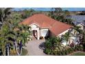 Aerial view of a beautiful single-story home featuring lush landscaping and a red tile roof at 4245 Corso Venetia Blvd, Venice, FL 34293