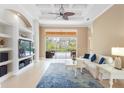 Bright living room featuring an entertainment center, tile flooring, and sliding doors to the pool at 4245 Corso Venetia Blvd, Venice, FL 34293