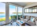 Bright living room with a comfortable sofa, stylish decor, and water views at 4310 Falmouth Dr # 102, Longboat Key, FL 34228