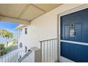 Inviting entrance featuring a blue front door, white textured walls, and stairs leading to stunning water views at 5031 N Beach Rd # 222, Englewood, FL 34223