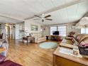 Cozy living room with ceiling fan, plush leather furniture, and wood-look flooring at 511 50Th Avenue W Dr, Bradenton, FL 34207