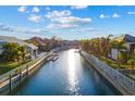 Picturesque canal lined with manicured properties, private docks, and lush palm trees under a sunny sky at 537 Fore Dr, Bradenton, FL 34208